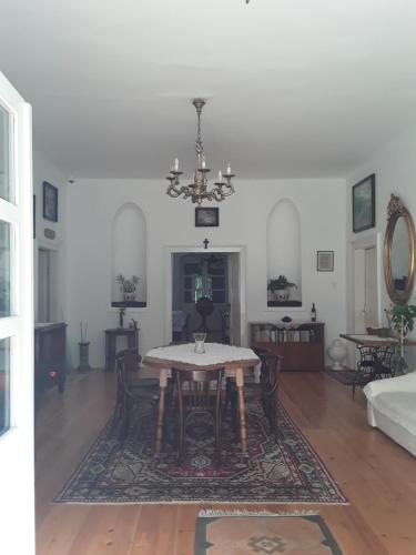 a dining room with a table and a chandelier at Igmándy kúria in Nagybajom