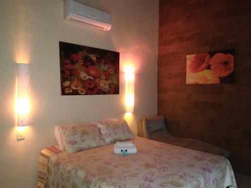 a bedroom with a bed and two pictures on the wall at Hotel Praia Do Rosa in Praia do Rosa
