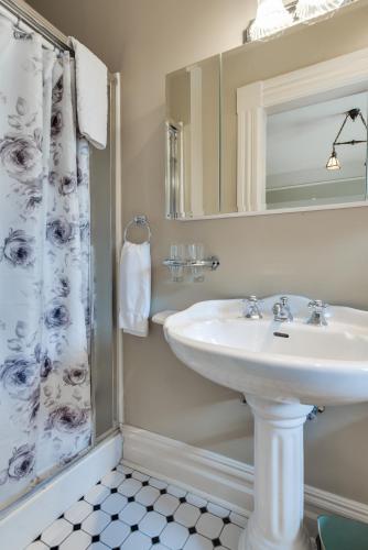 a bathroom with a sink and a shower curtain at O Canada House Bed & Breakfast in Vancouver
