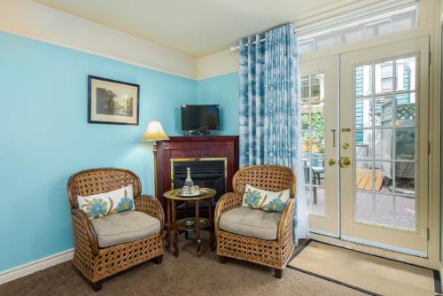 a living room with two chairs and a table and a tv at O Canada House Bed & Breakfast in Vancouver