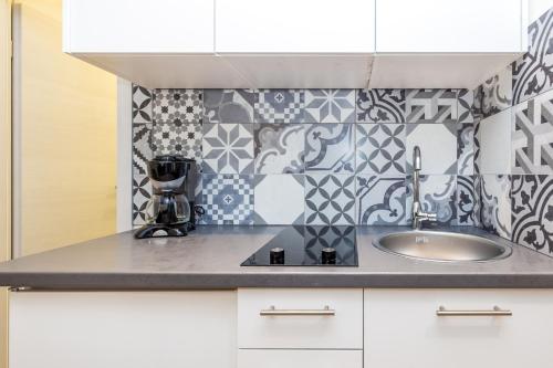 a kitchen with a sink and a tile wall at Flumen in Rijeka