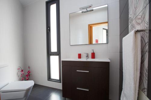 ein Bad mit einem Waschbecken und einem Spiegel in der Unterkunft Villa Maciel in Calheta