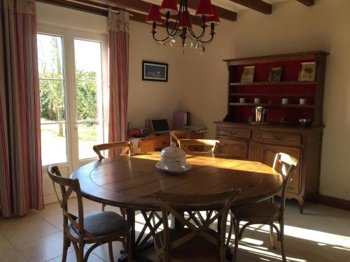 une salle à manger avec une table et des chaises en bois dans l'établissement Villa Cotentin, à Réville