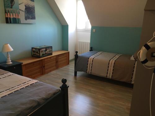 a bedroom with two beds and a window at Villa Cotentin in Réville
