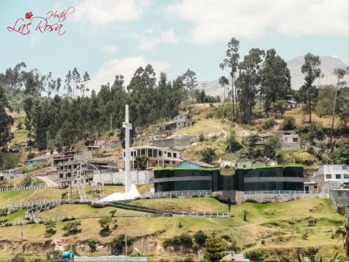a village on a hill with a windmill at Hostal La Rosa Otavalo in Otavalo