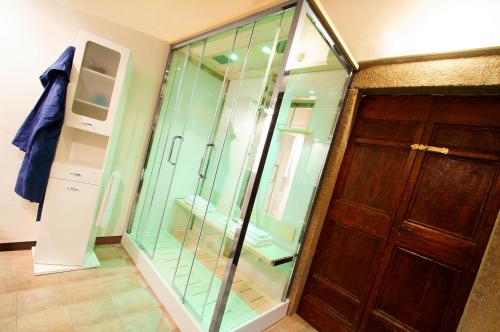 a glass shower in a room with a door at A Priori Guest House in Viterbo