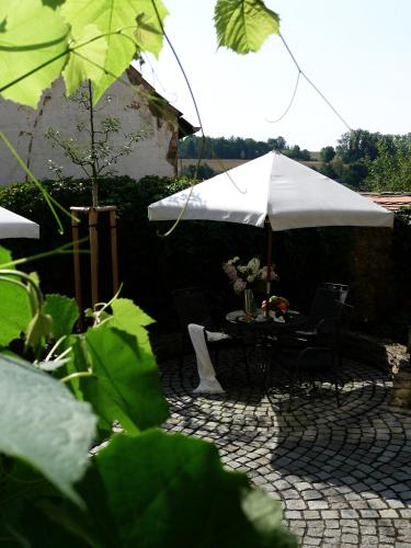 a patio with a table and an umbrella at Penzion Štybar in Stříbro