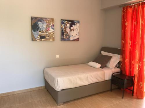 a bedroom with a bed and two pictures on the wall at House with sea and mountain view in Markópoulon Oropoú