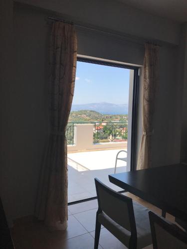a room with a window with a table and a view at House with sea and mountain view in Markópoulon Oropoú