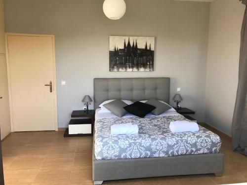 a bedroom with a bed and a picture on the wall at House with sea and mountain view in Markópoulon Oropoú