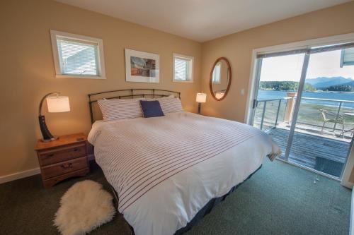 a bedroom with a bed with a view of the water at Waterfront Condo by OnlyBC 202 in Tofino