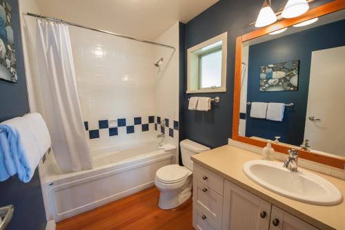 La salle de bains est pourvue d'un lavabo, d'une baignoire et de toilettes. dans l'établissement Waterfront Condo by OnlyBC 202, à Tofino
