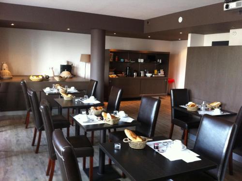 um restaurante com mesas e cadeiras com comida em Hôtel Bar le Globe em Saint Die