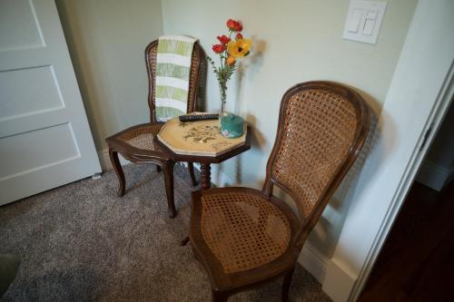 a table and two chairs and a vase with flowers on it at Poppy Sister Inn in Lodi