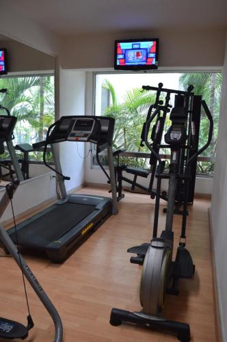 a gym with two tread machines and a tv at Ambiance Suites in Cancún