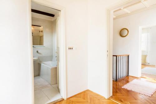 a bathroom with white walls and a tub and a toilet at Villa Pavlović in Herceg-Novi