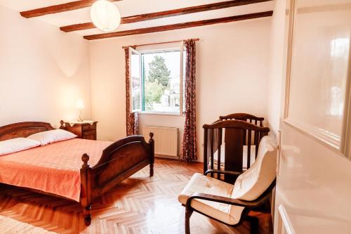 a bedroom with a bed and a chair and a window at Villa Pavlović in Herceg-Novi