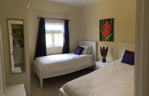 a bedroom with two beds and a window at South Sea House in Cap Estate