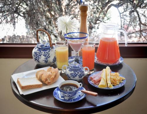 een tafel met een dienblad met ontbijtproducten en -dranken bij Anami Hotel Boutique in La Paz