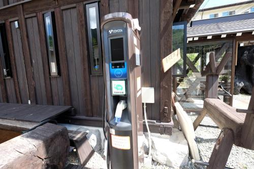 a parking meter in front of a wooden building at Tsuyukusa in Takayama