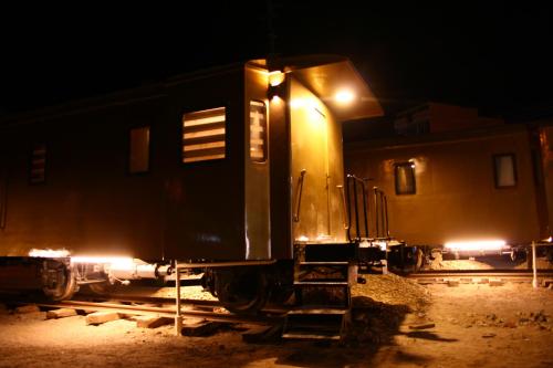 a train car sitting on the tracks at night at Onkel Inn Wagon Sleepbox Uyuni in Uyuni
