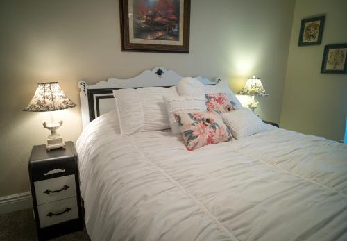 a bedroom with a large white bed with two lamps at Poppy Sister Inn in Lodi