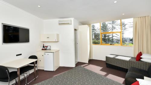 a living room filled with furniture and a tv at Atlantic Tower Motor Inn in Adelaide