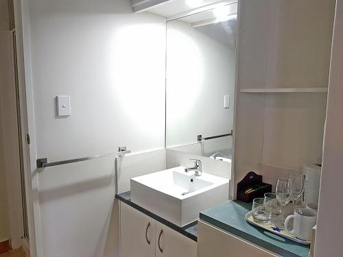 bagno con lavandino bianco e specchio di VR Auckland Airport ad Auckland