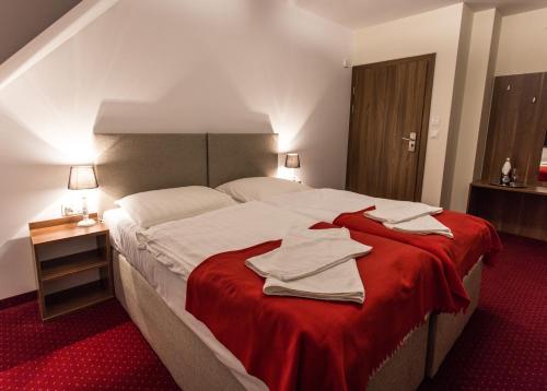 Noclegi Gawra في كيبنو: غرفة نوم بسرير كبير مع بطانية حمراء