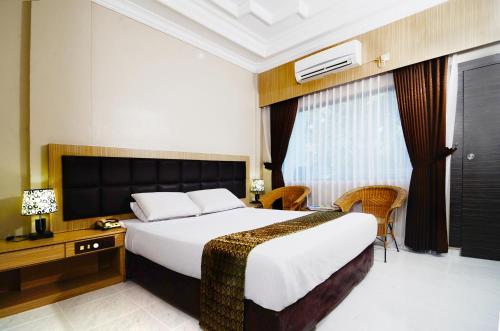 Habitación de hotel con cama grande y escritorio. en Pelangi Hotel & Resort en Tanjung Pinang
