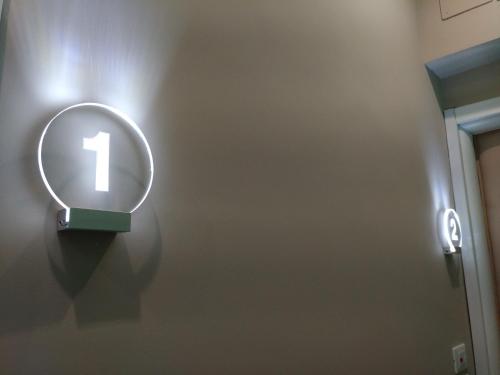 a lighted sign on the wall of a bathroom at Domus Nova in Reggio Calabria