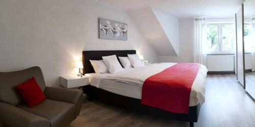a bedroom with a large bed and a chair at Ferienwohnung Brautrock in Bullay