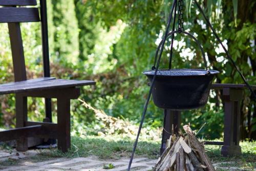 a bucket hanging from a pole next to a bench at Malomtavi Vendégház in Tapolca