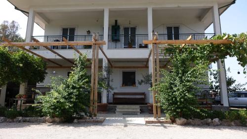 a white house with a porch and a balcony at Casa Vacanze Feudi 1165 in Borgo Vodice