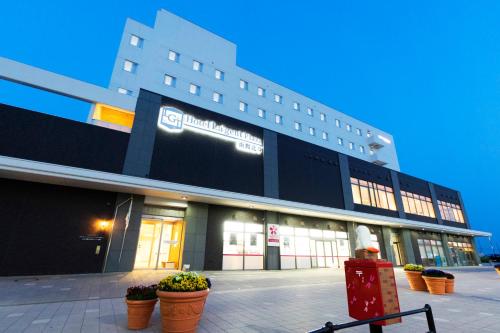 a large building with potted plants in front of it at Hotel La'gent Plaza Hakodate Hokuto in Hokuto