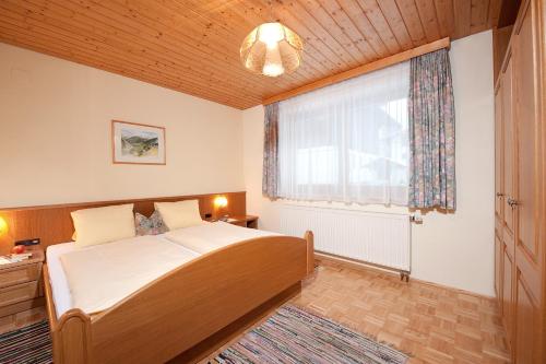 a bedroom with a bed and a large window at Haus Grutschnigg in Bad Gastein