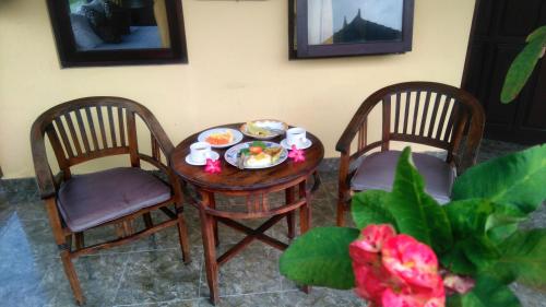 un tavolo con una ciotola di cibo e due sedie di Suwar Bungalows ad Ubud