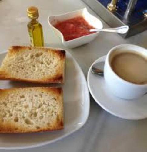 un piatto con due fette di pane e una tazza di caffè di Hotel Sierra de Andujar a Virgen de la Cabeza