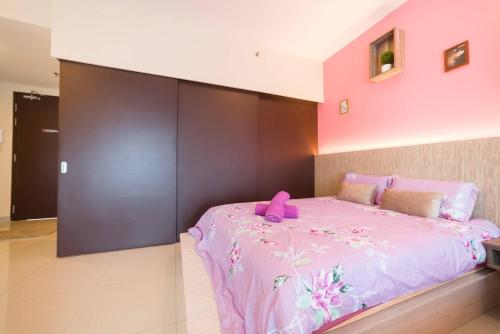 a pink bedroom with a large bed with a pink headboard at Studio Room next to SCCC at Trefoil Setia Alam for 2-4 pax in Setia Alam