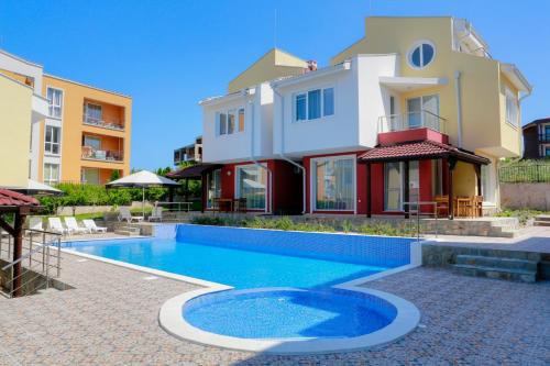 uma casa com piscina em frente a uma casa em St. Stefan Villas & Hotel em Sozopol