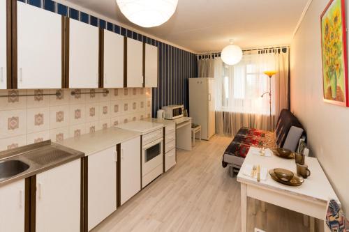 モスクワにあるАпартаменты Кастанаевская 7の白いキャビネット付きのキッチン、リビングルーム