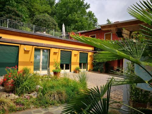 a house with green shutters on the side of it at Casa Margherita in Villar San Costanzo