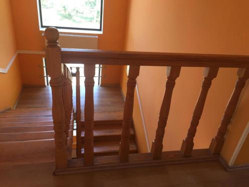 a staircase with a wooden rail and a window at Hotel Kavkasioni in Kvareli