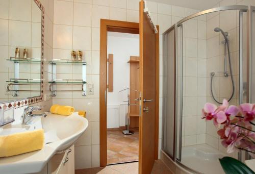 La salle de bains est pourvue d'un lavabo et d'une douche. dans l'établissement Appartements Oberhauser, à Westendorf