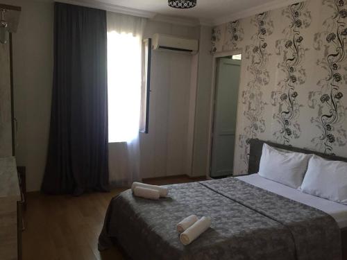 a bedroom with a bed with two towels on it at Hotel Kavkasioni in Kvareli