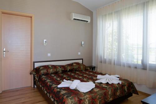 a bedroom with a bed with two towels on it at Saint Stefan Villas in Sozopol