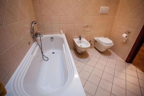 a bathroom with a white tub and a toilet at Erasippe Residence in Locri