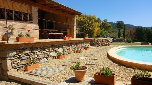 a backyard with a swimming pool and potted plants at Can Santalo in Cantallops