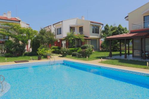 a large swimming pool in front of a house at Saint Stefan Villas in Sozopol