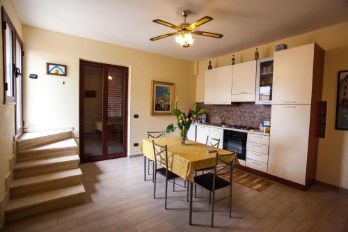 une cuisine avec une table et des chaises ainsi qu'un ventilateur de plafond dans l'établissement Erasippe Residence, à Locri